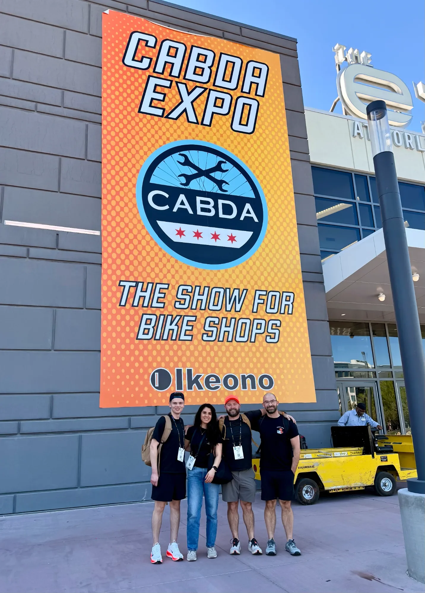 Four Ikeono team members standing under the Ikeono-sponsored CABDA Expo banner