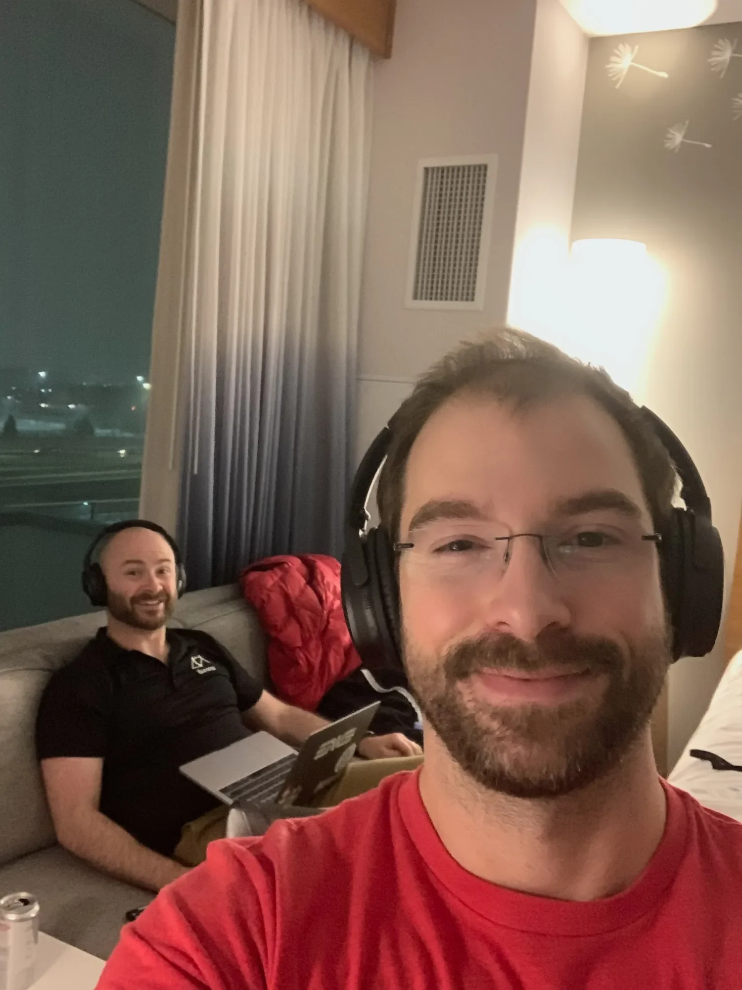 Two Ikeono co-founders working late on laptops in a hotel room