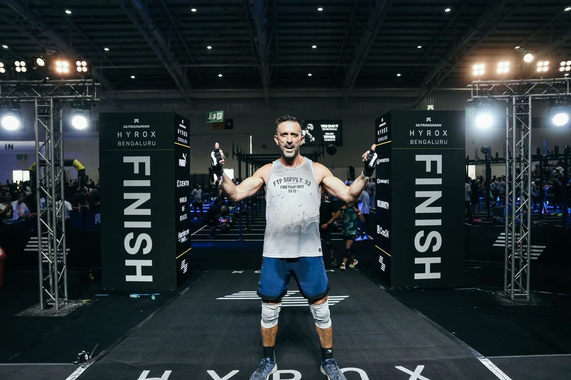 Robert Townson at the HYROX Bengaluru 2026 finish line with arms raised, trained by Fitness Bootcamp in Rishikesh