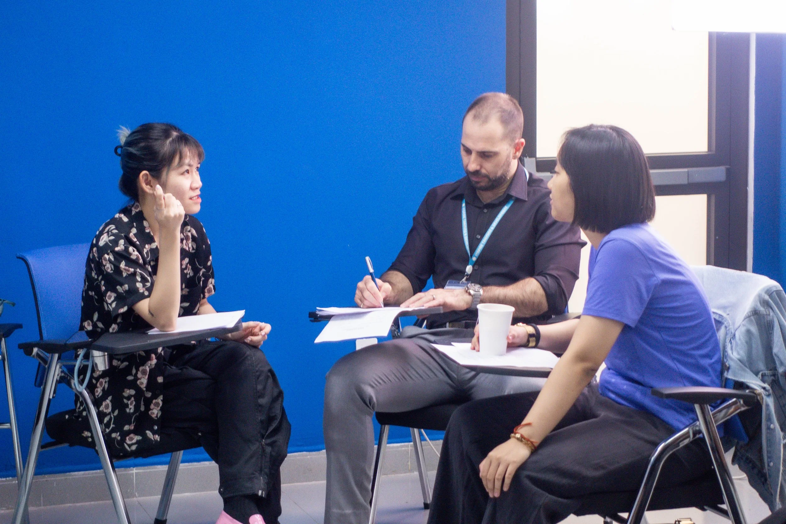 Teacher supporting learners during a practical writing workshop