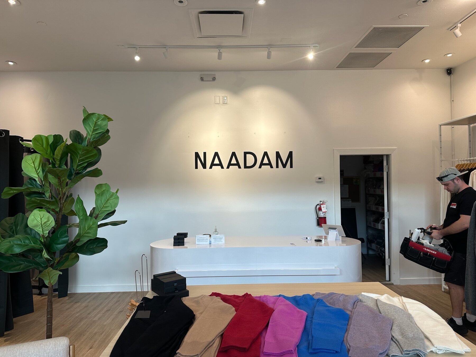 NAADAM black dimensional logo installed behind a reception desk