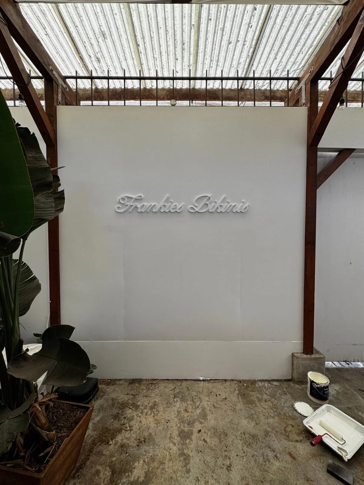 Frankies Bikinis dimensional script logo mounted on an interior wall
