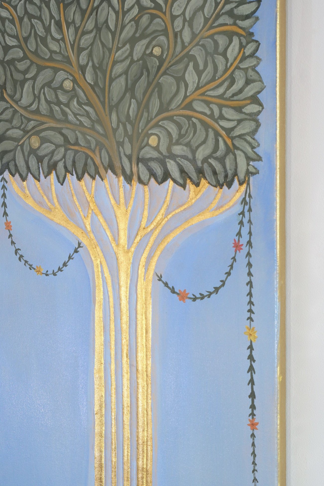 Der Baum aus der Nähe: der goldene Stamm fächert sich nach oben in die grüne Krone, an den Ästen hängen Girlanden aus kleinen Blättern und Blüten.