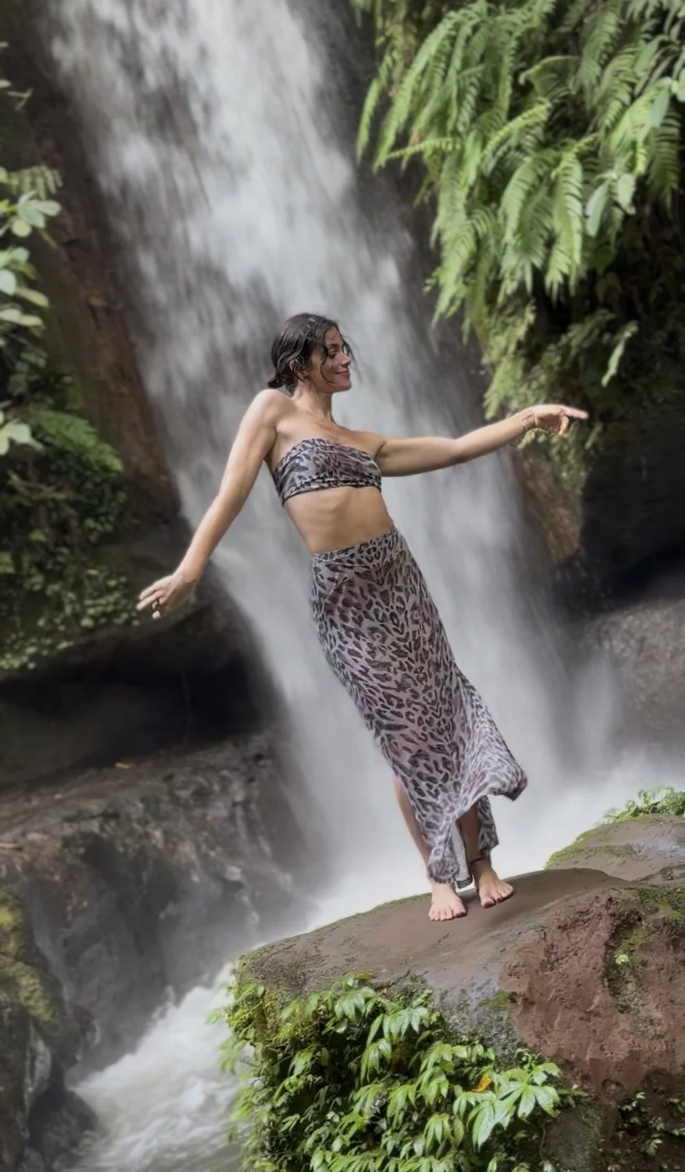 Laura, coach en féminité et sensualité, danse devant une cascade