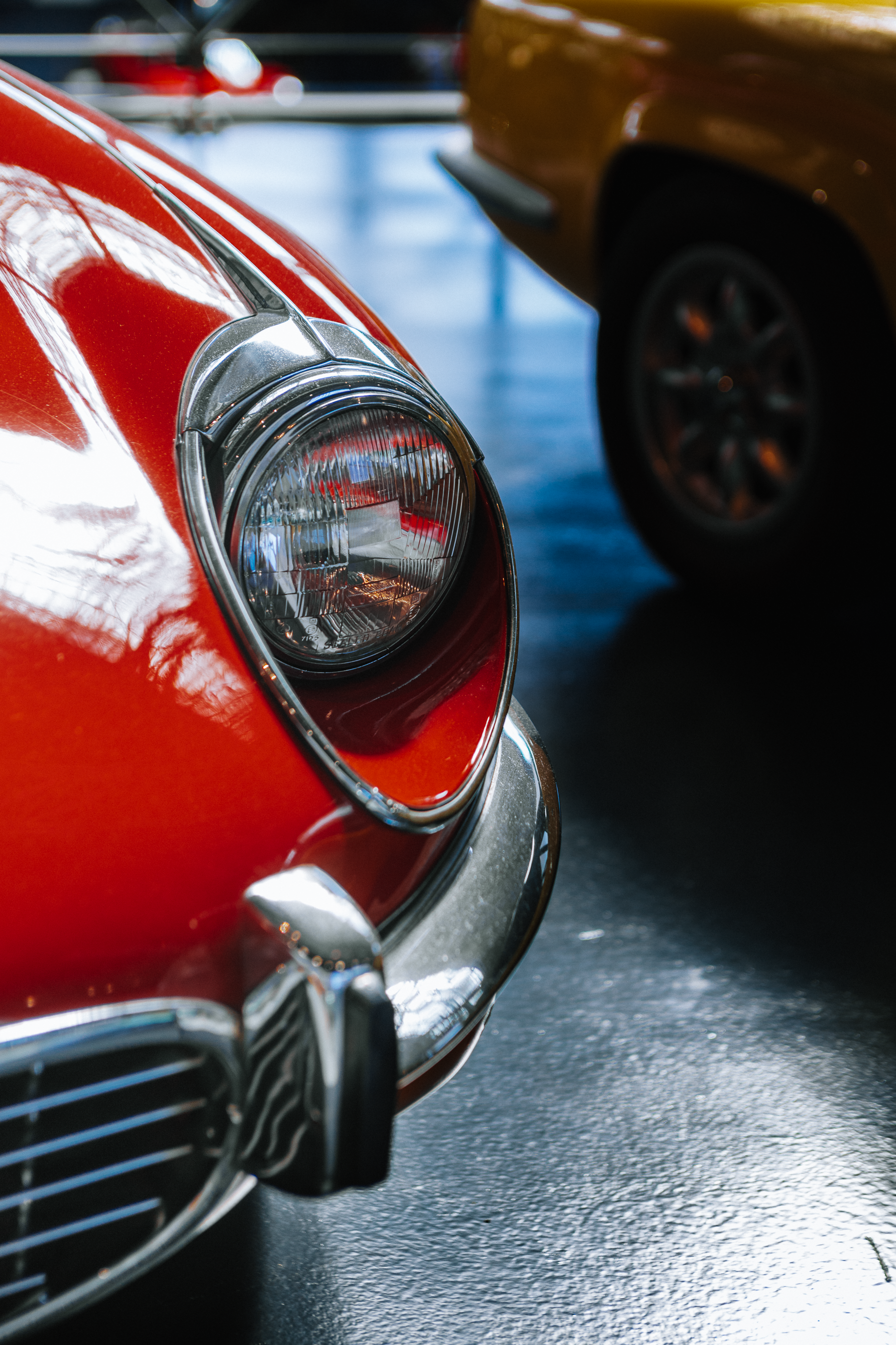 Gros plan du phare avant d'une Jaguar E-Type classique Autoworld Bruxelles - Anthony Junet Photographe Automobile France