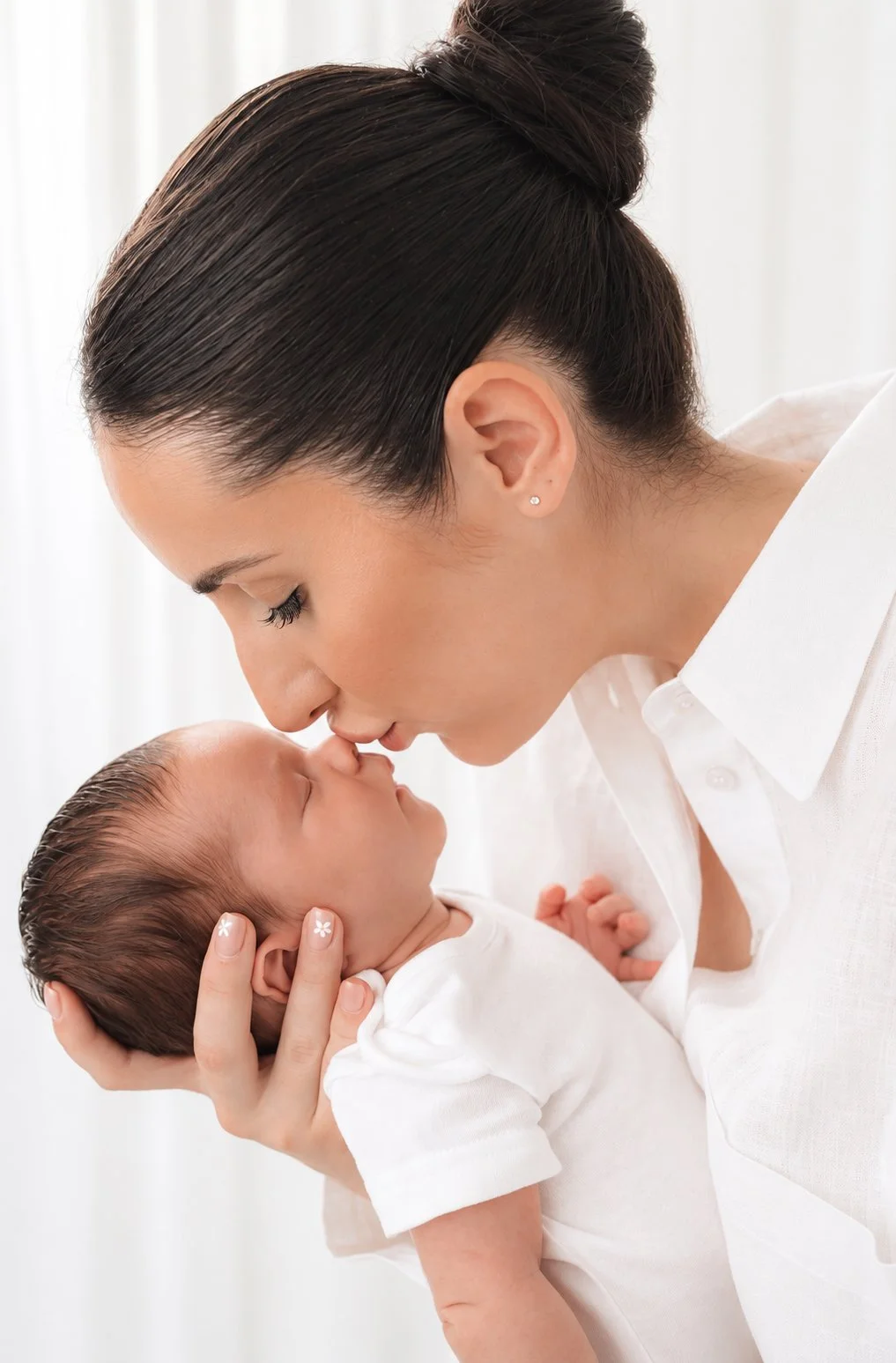 Mother kissing her newborn baby