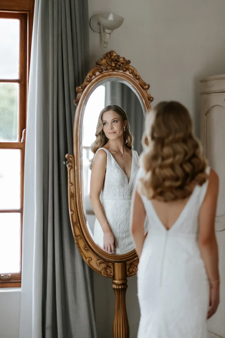 Bride reflected in an antique mirror while getting ready