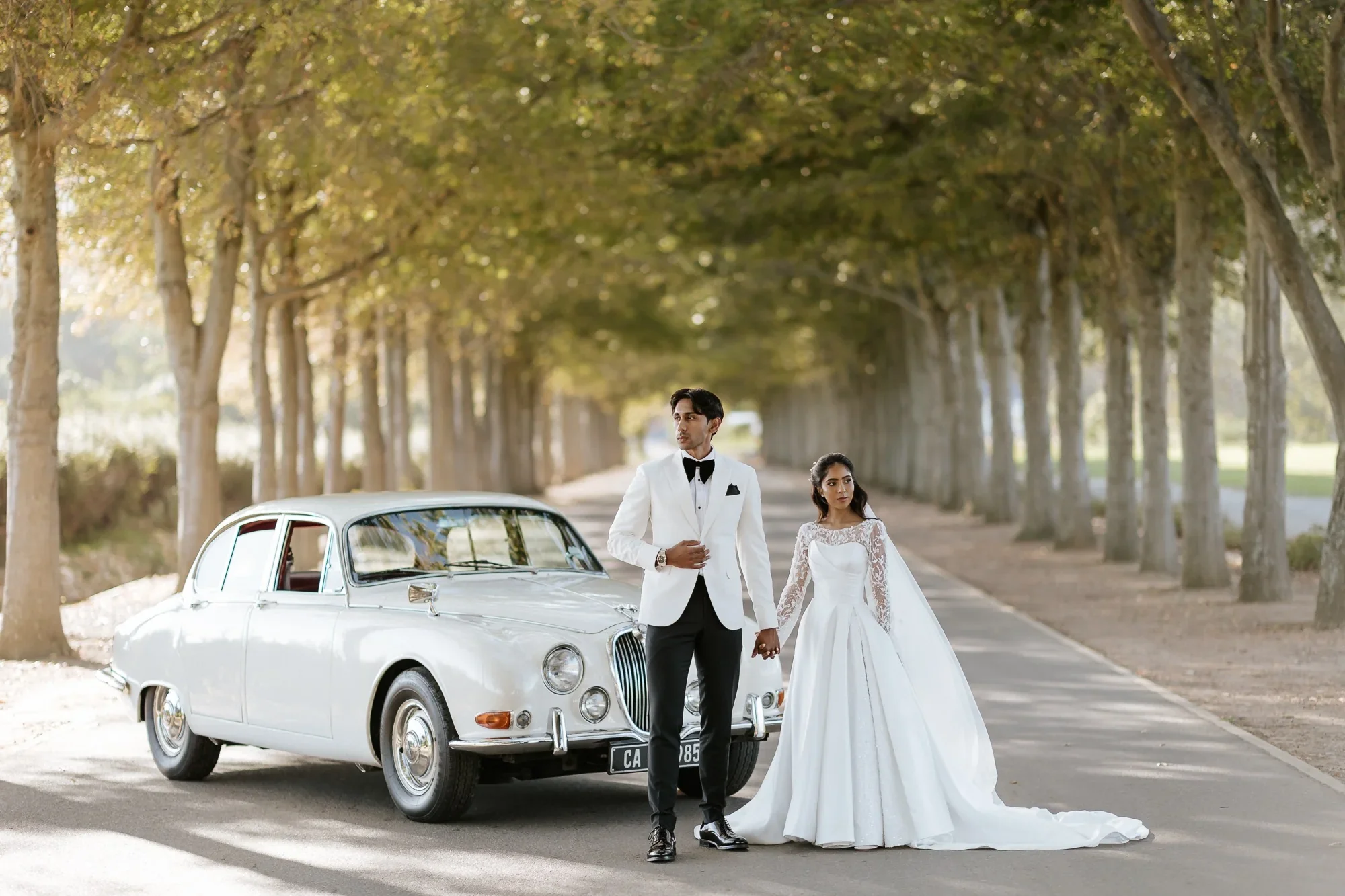 Editorial wedding portrait beside classic car