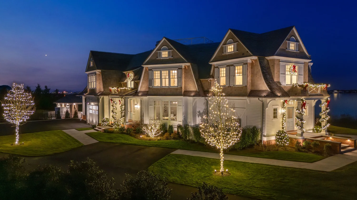 Professionally designed holiday lighting illuminating a luxury New Jersey home at night