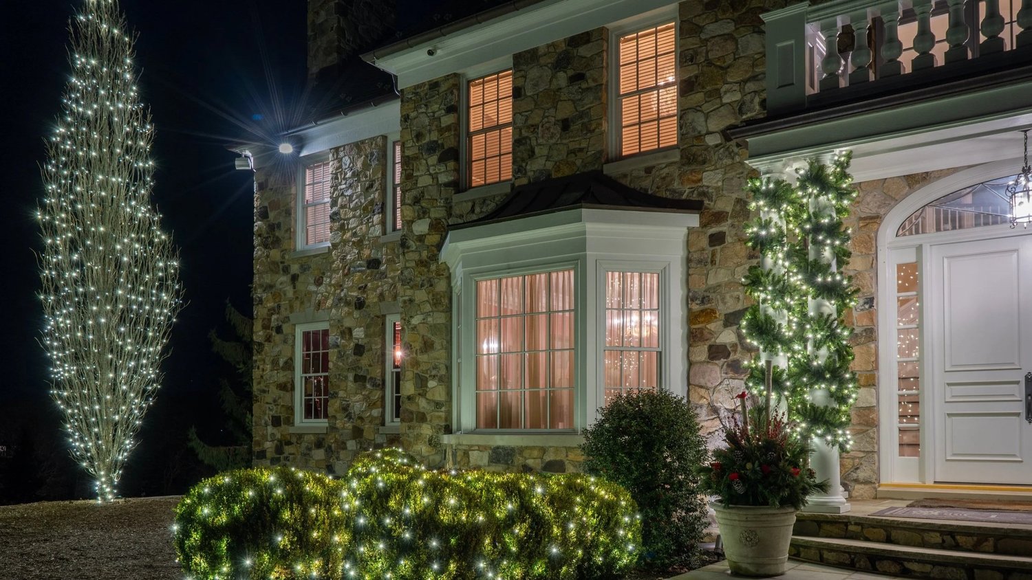 Refined holiday lighting integrated into the architecture and landscape of a New Jersey residence