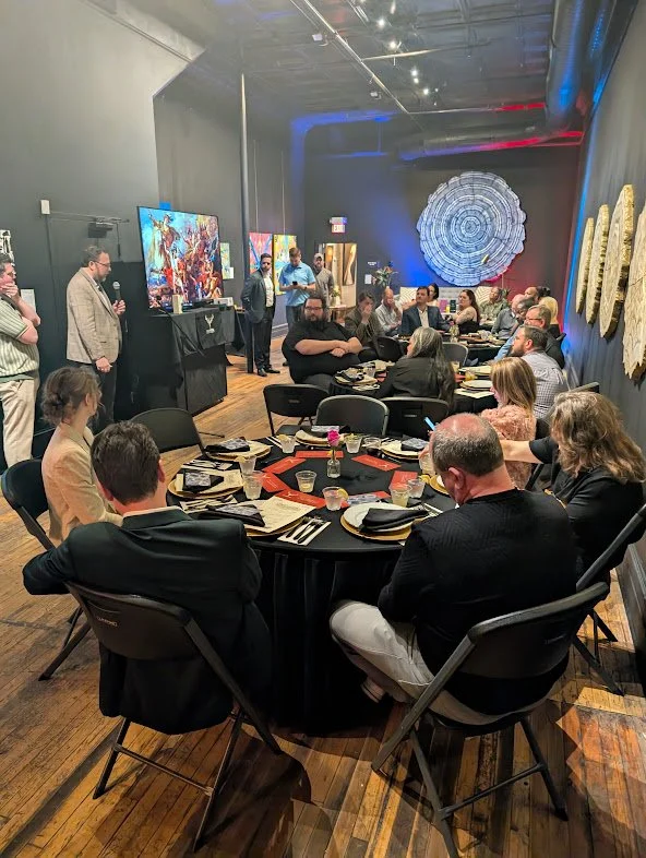 Guests seated for dinner in the Black Iris art gallery