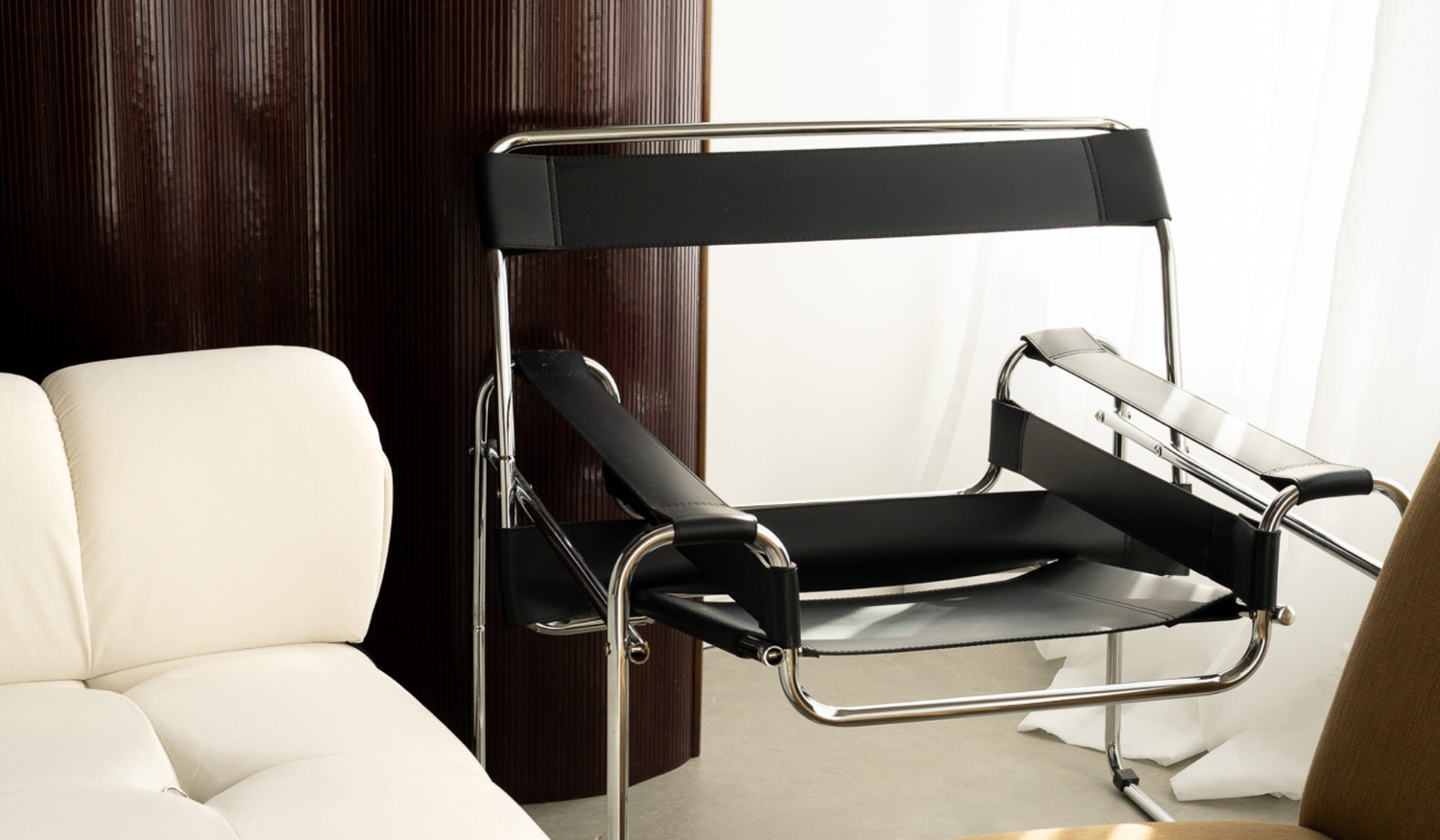 Black leather and chrome chair in front of a wood divider.