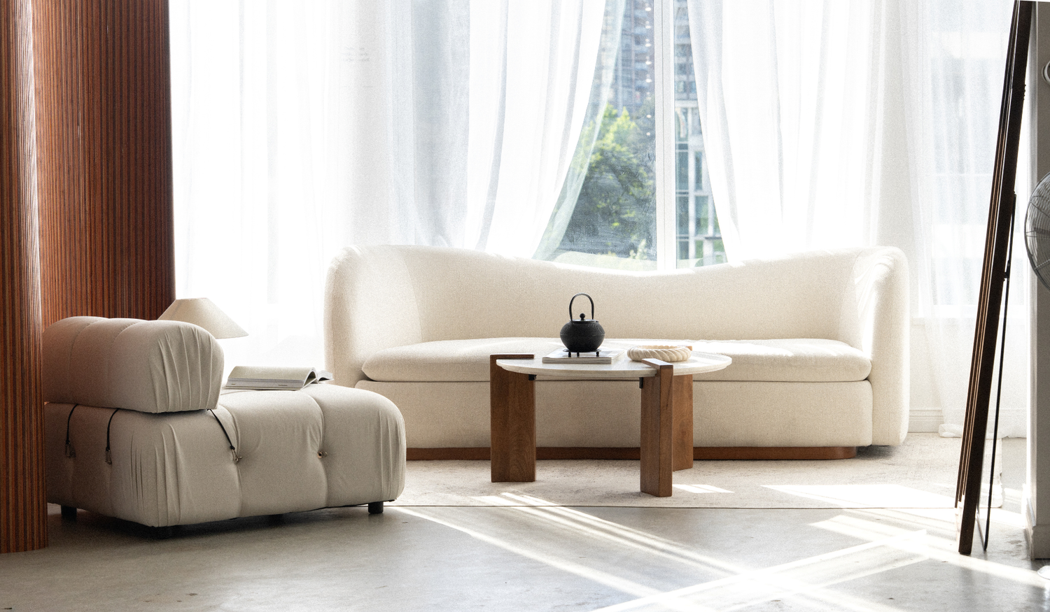 Front view of the cream sofa and round coffee table in natural light.