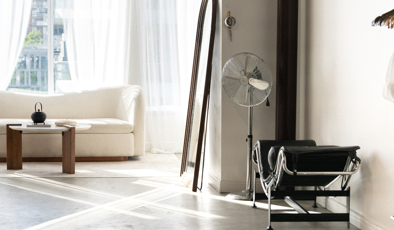 Black and chrome chair beside the arched mirror and studio seating.