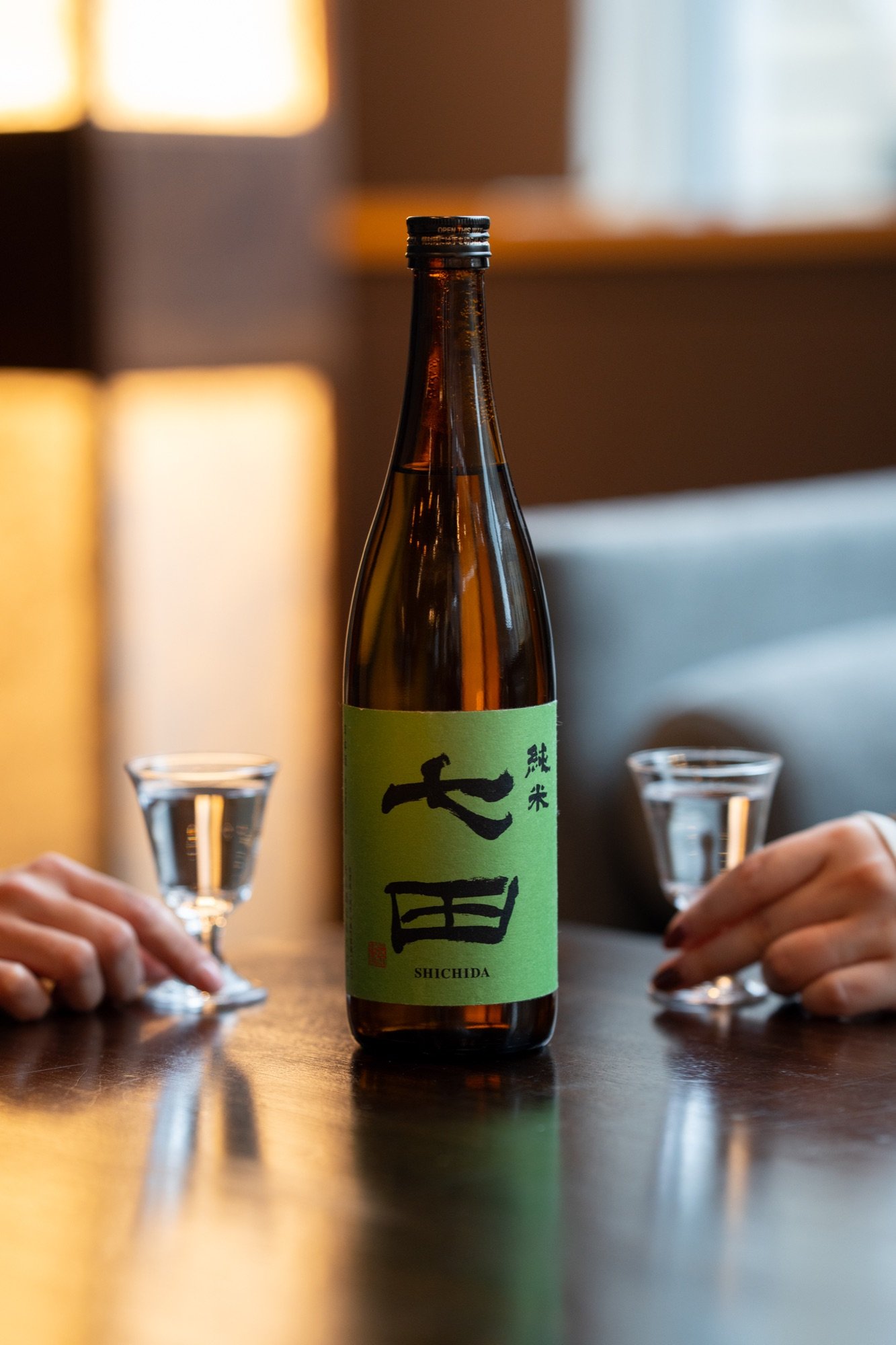 Sake bottle and glasses photographed at Hush Coffee