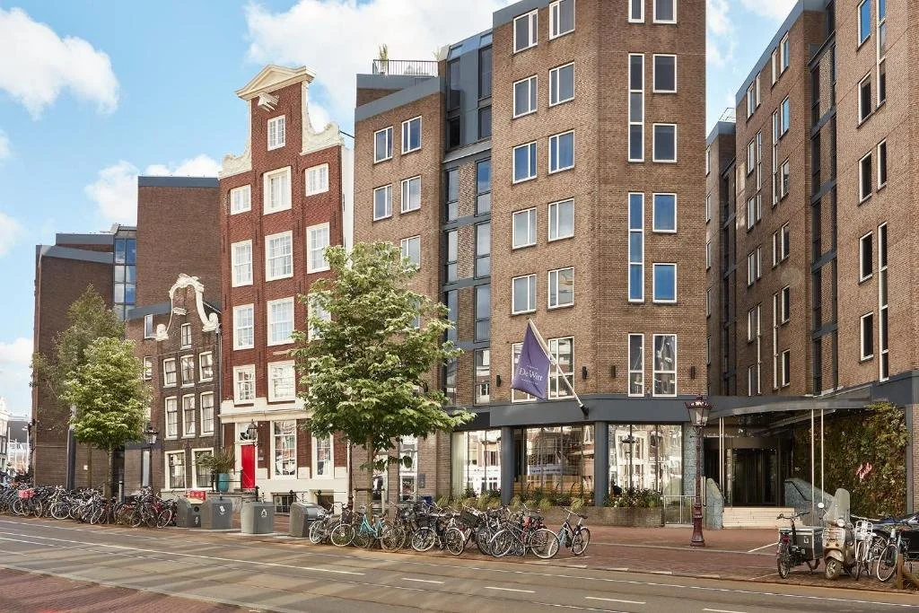 eine Reihe von Gebäuden mit davor geparkten Fahrrädern in der Unterkunft Kimpton De Witt Amsterdam by IHG in Amsterdam