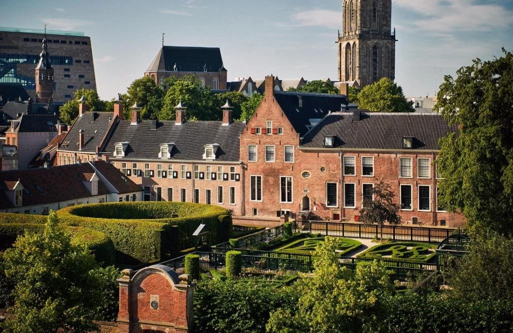 Blick auf eine Stadt mit einem Uhrturm in der Unterkunft Prinsenhof in Groningen