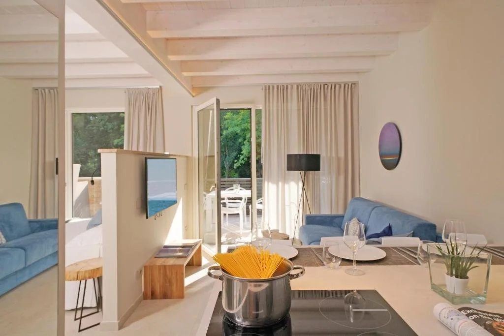 Heller Wohnbereich mit Küche, blauem Sofa und Terrasse im Lamasu RioVerde in San Felice del Benaco