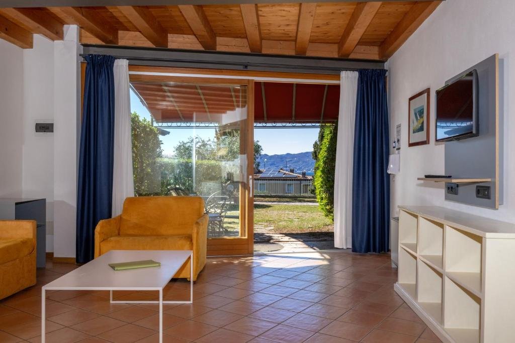 Wohnbereich mit Gartenterrasse und Seeblick in der Residence Ca Del Lago