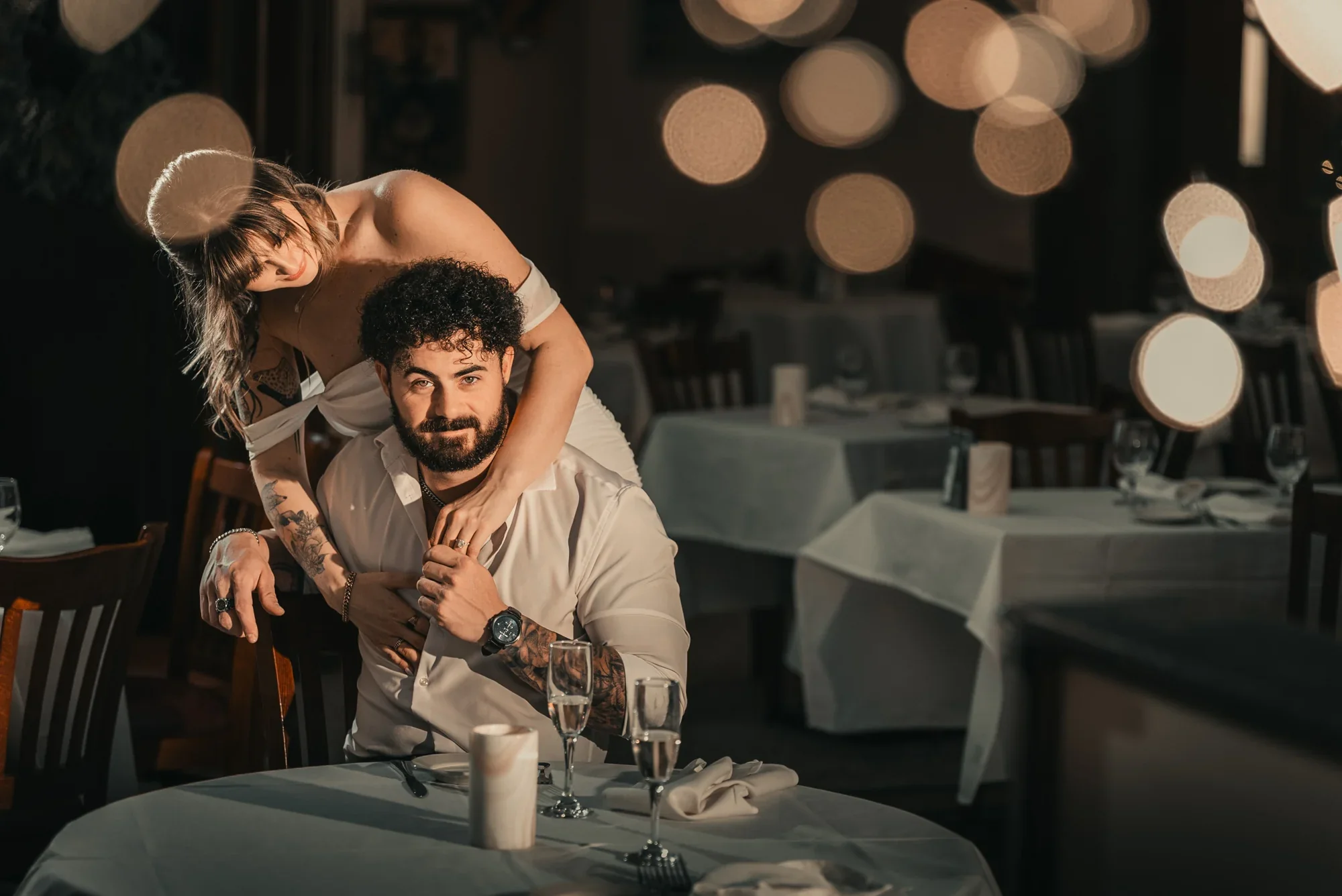 Kari leans over Josh’s shoulder during their engagement portraits at Remlik’s.