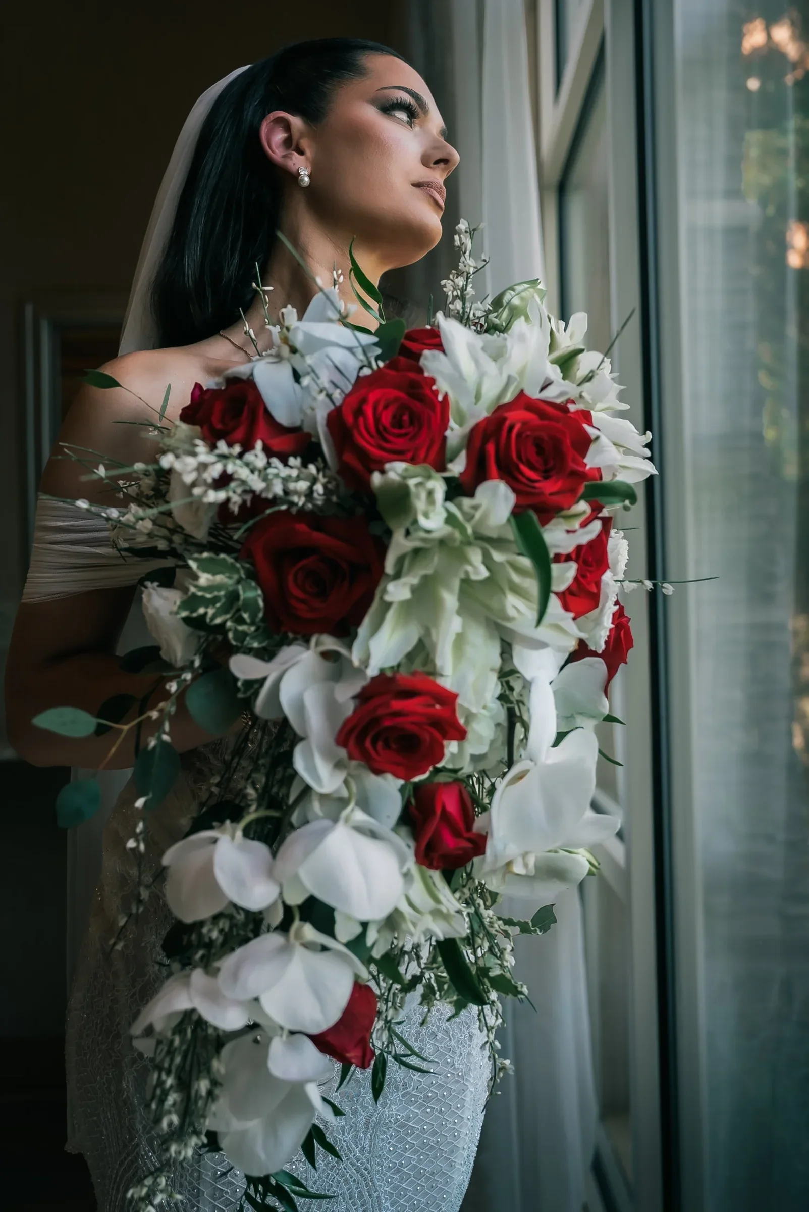 Vanessa gazing out the window, her veil down her back and her bouquet falling nearly to her knees