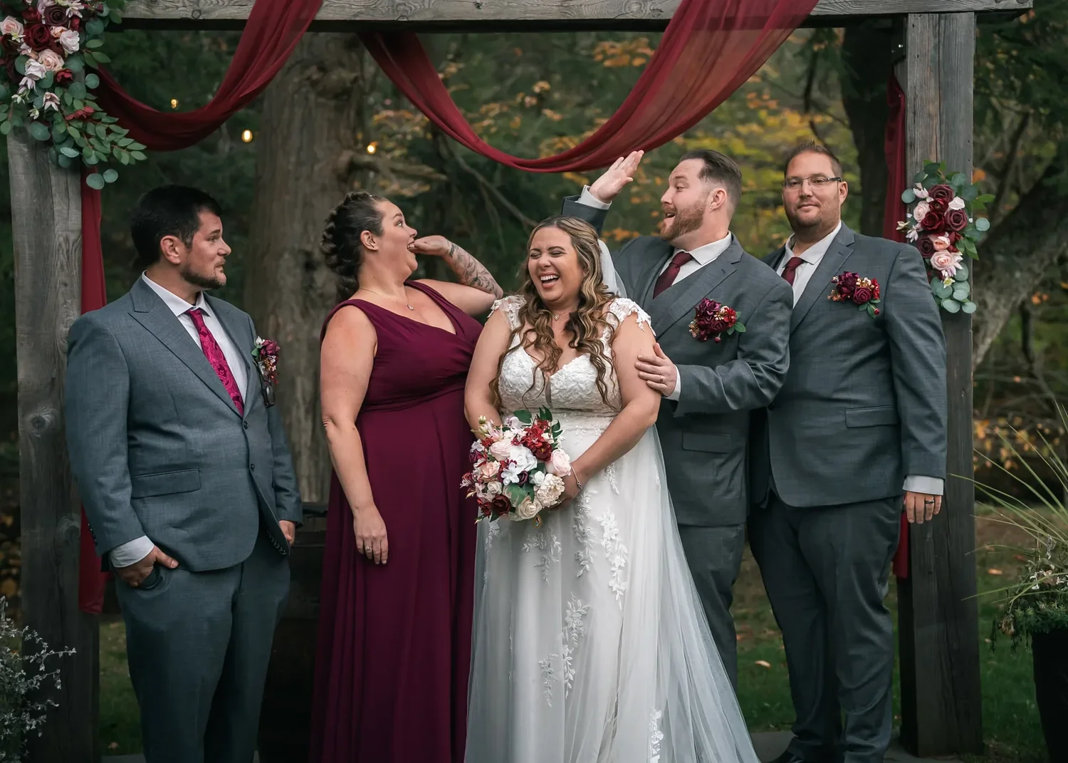 Wedding party portrait beneath the outdoor ceremony backdrop at Stoney Creek Castle