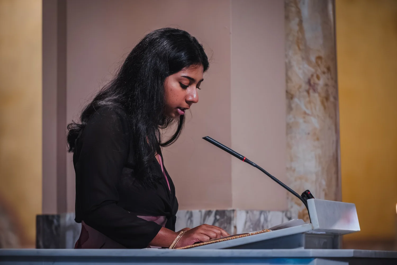 A woman giving a reading at the lectern inside St. John the Evangelist church