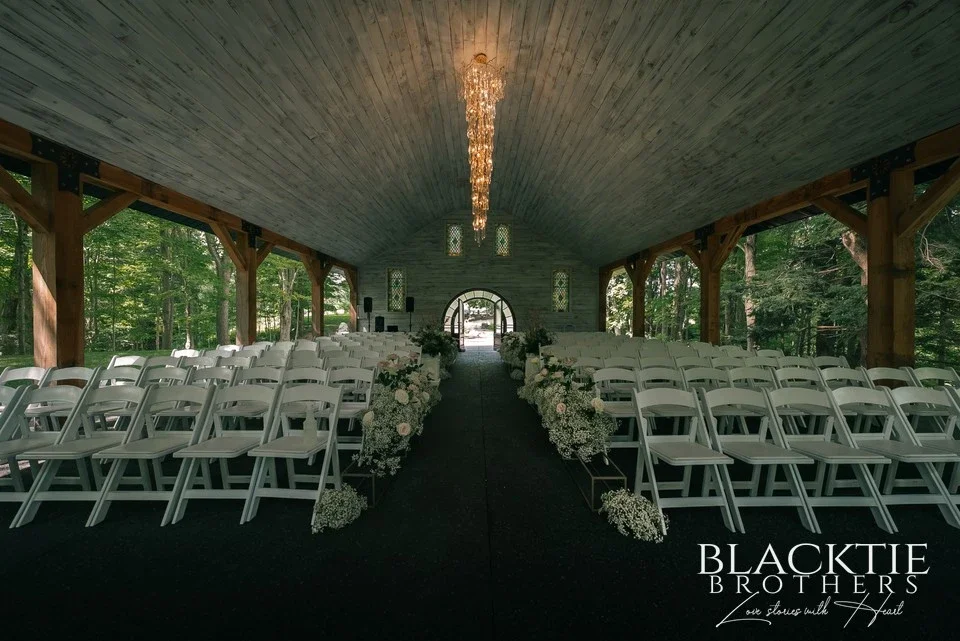 The chapel interior at LedgeRock, set with white chairs and florals down the aisle before guests arrive.