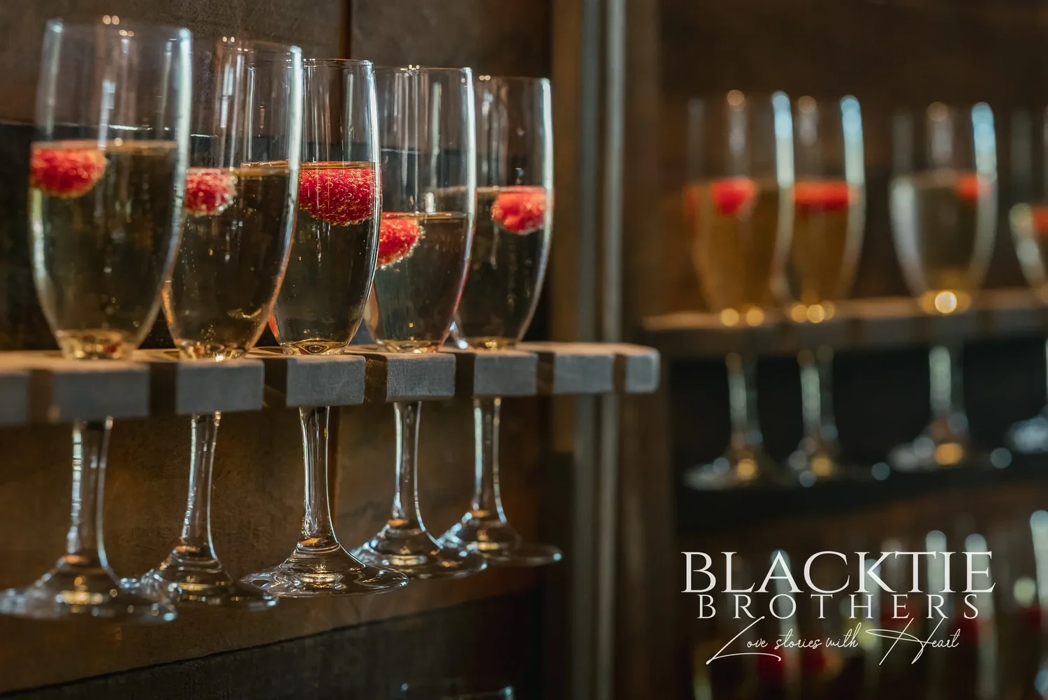 A row of champagne flutes with raspberries, ready at the bar at Allyn Lodge.