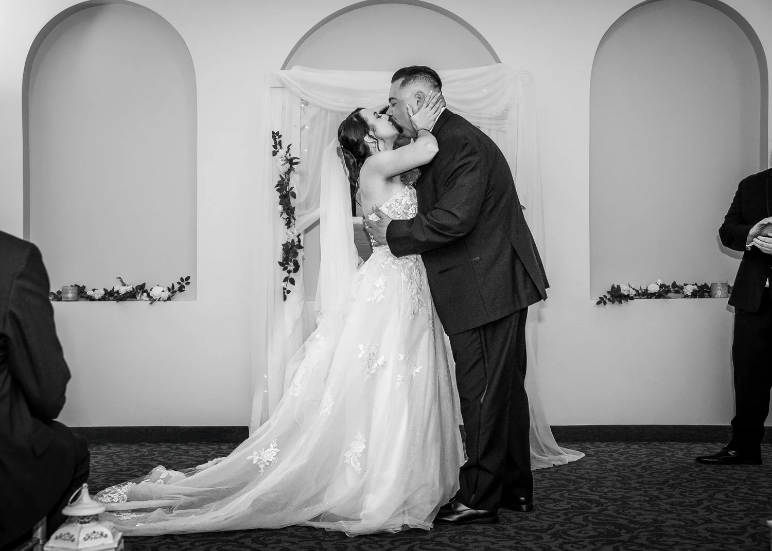 Laura and Dante’s first kiss at the front of the ceremony room, in black and white