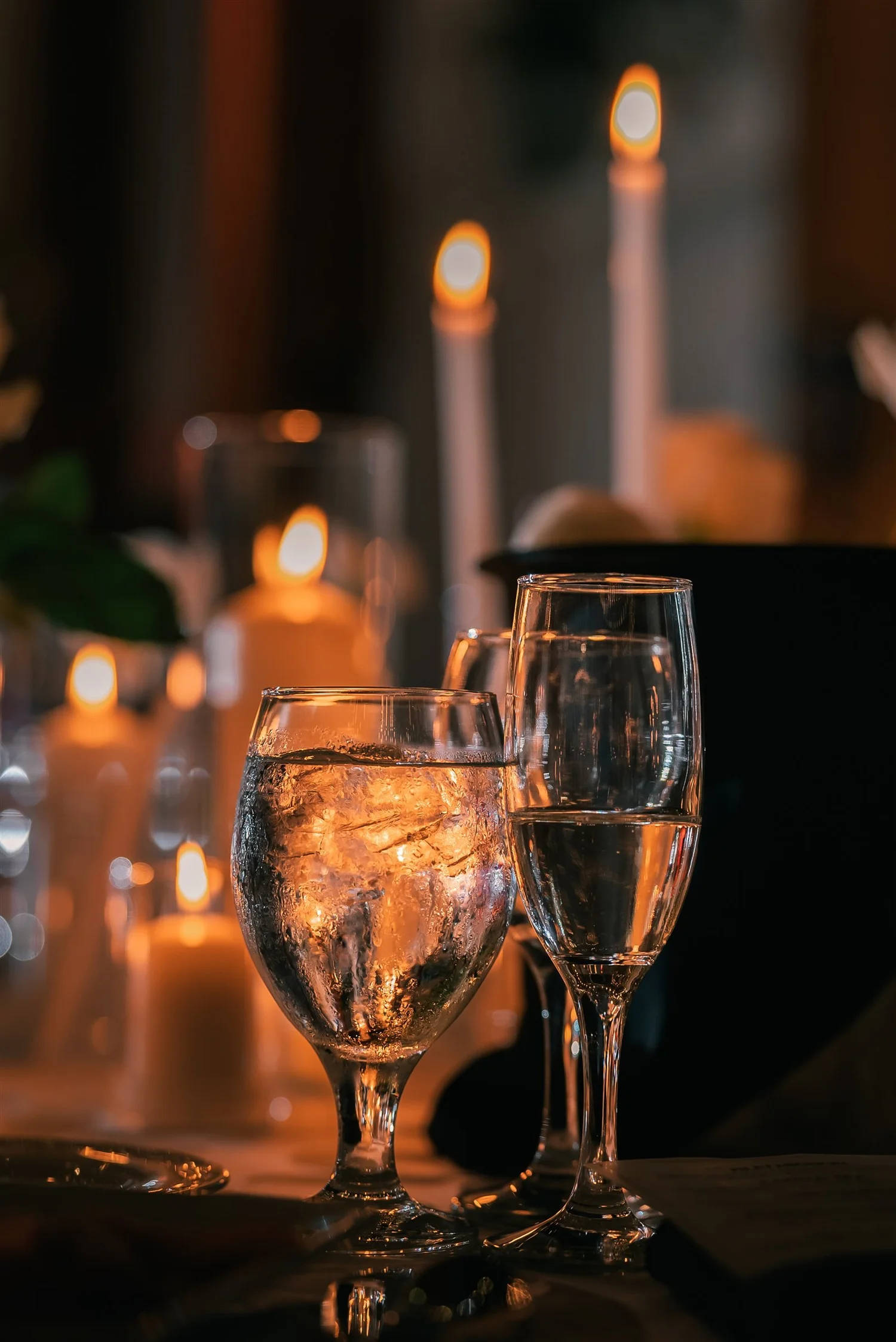Candlelight reflects through glassware on a reception table at The Somerley.