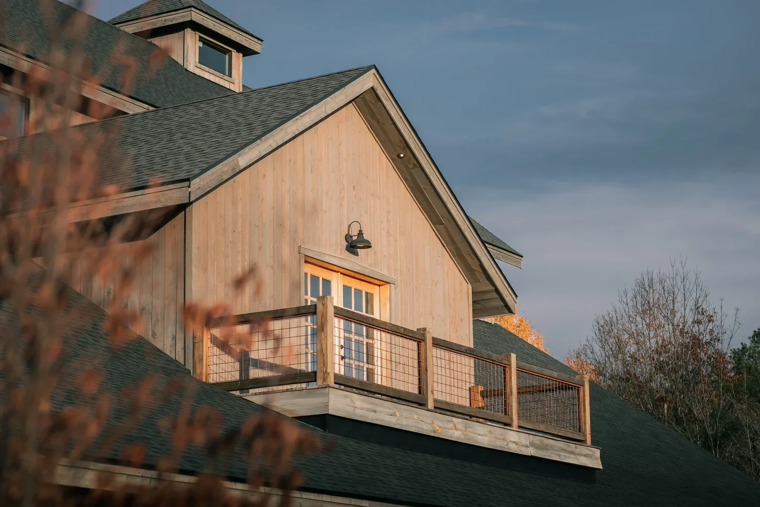 Warm late light on the timber siding and balcony of the Barn at Windham Manor