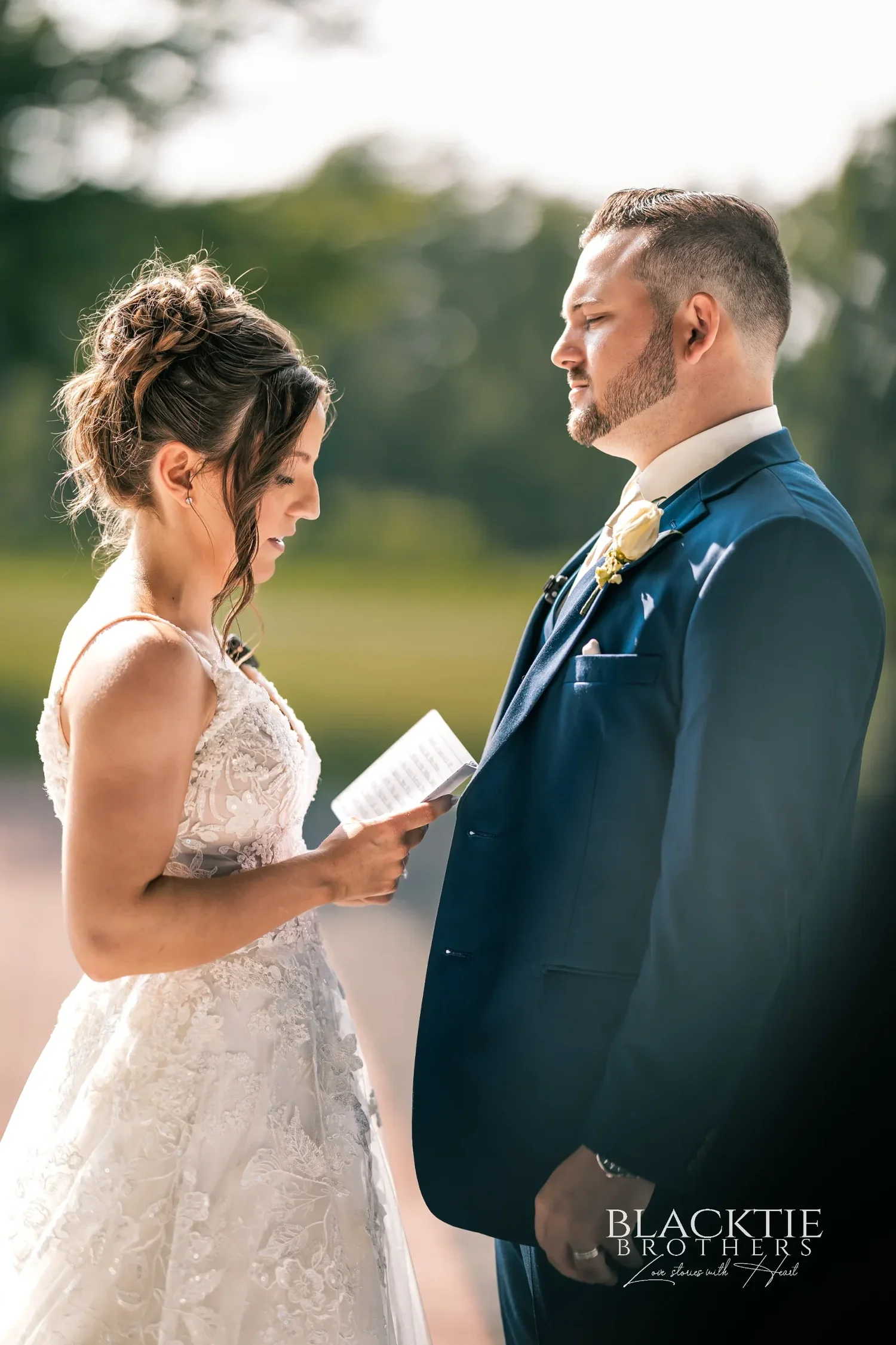 Taylor reading private vows from a card to Jake on the course in the evening light, both in profile