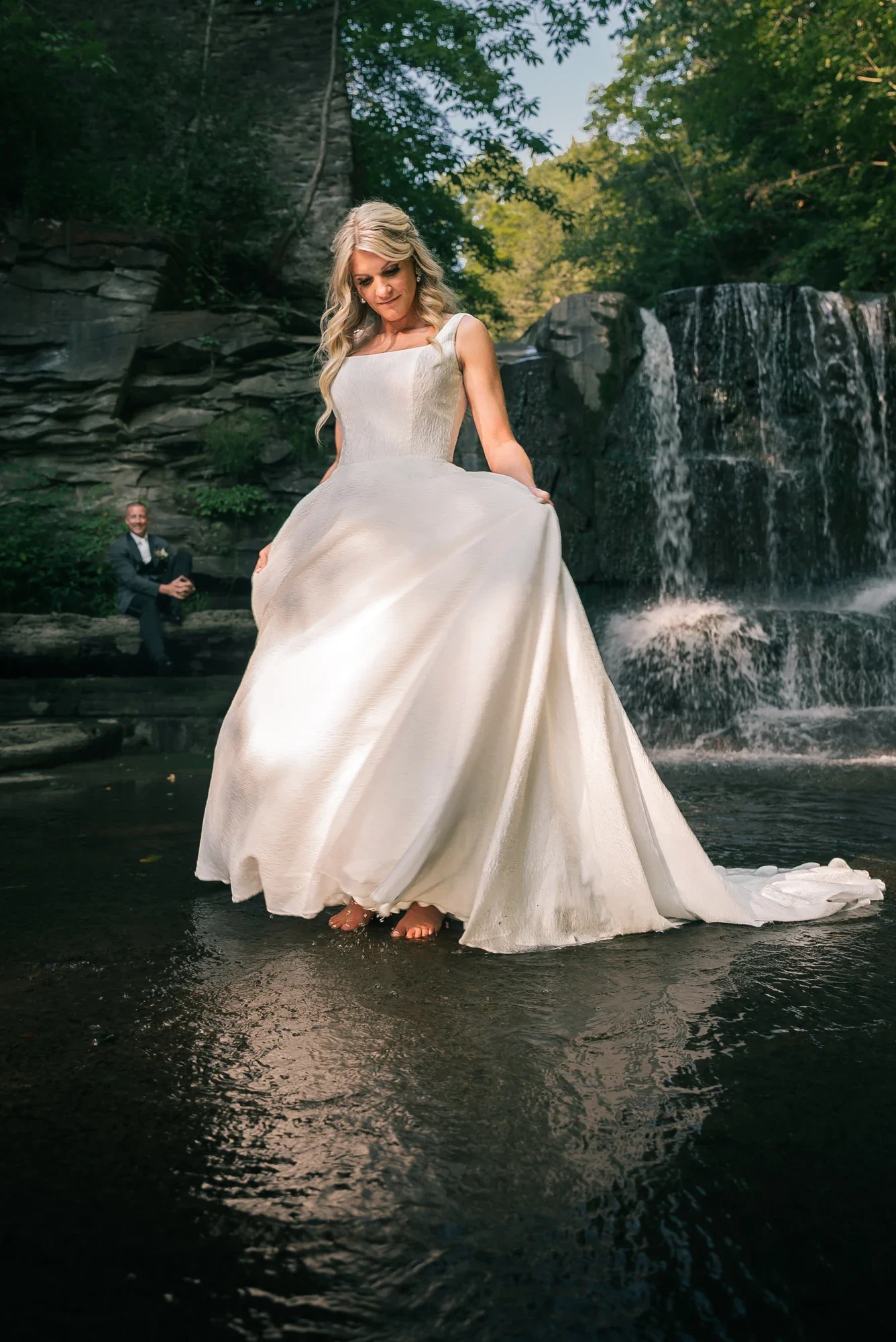 Bride standing in the water below the private waterfall at LedgeRock.