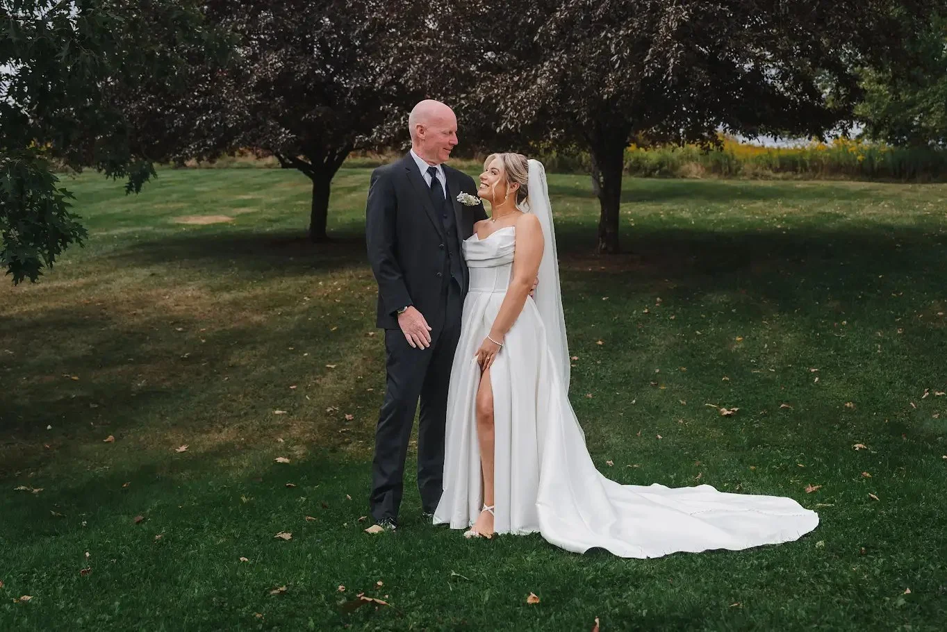 Bride and her father standing beneath a tree on Stonewall Estate's lawn