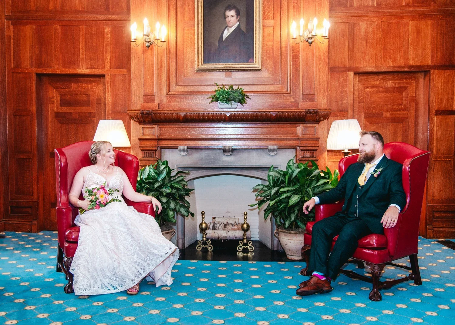Amanda and Chris seated in a wood-paneled room at The Otesaga