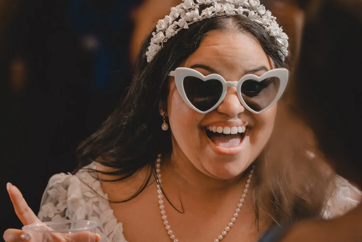 Jessica laughing in heart-shaped white sunglasses on the dance floor