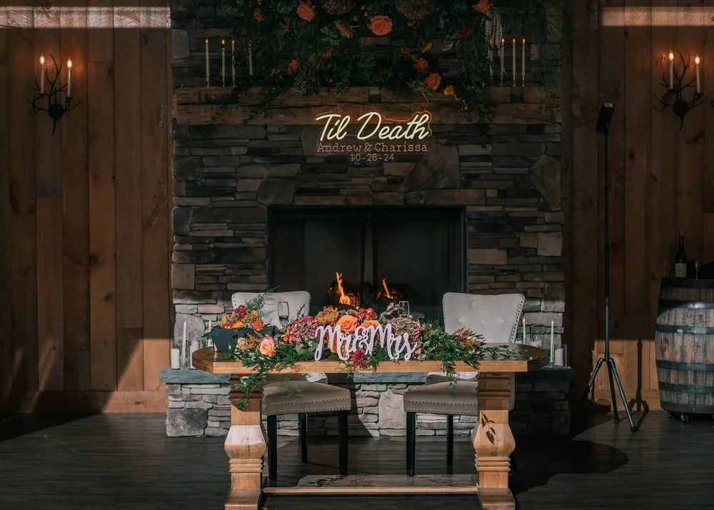 Wedding reception decor arranged around Windham Manor's stone fireplace