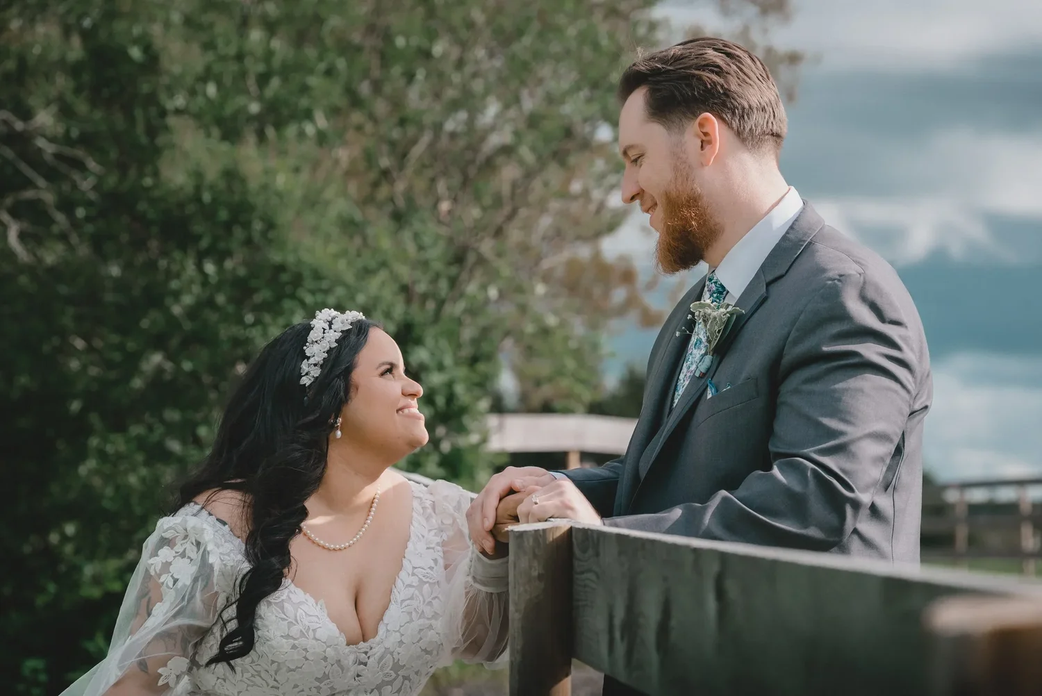 Jessica smiling up at Christian as they lean on a wooden fence at Knotting Hill Farm