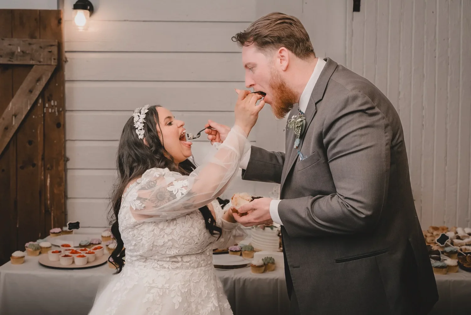 Christian feeding Jessica a bite of wedding cake at the dessert table