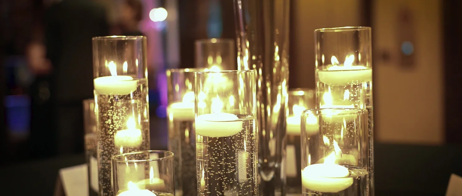 Glowing candles in glass holders at Catie and Brad's wedding reception