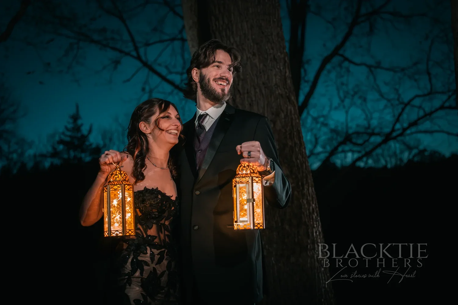 Maddy and Dan holding glowing lanterns in the woods at night