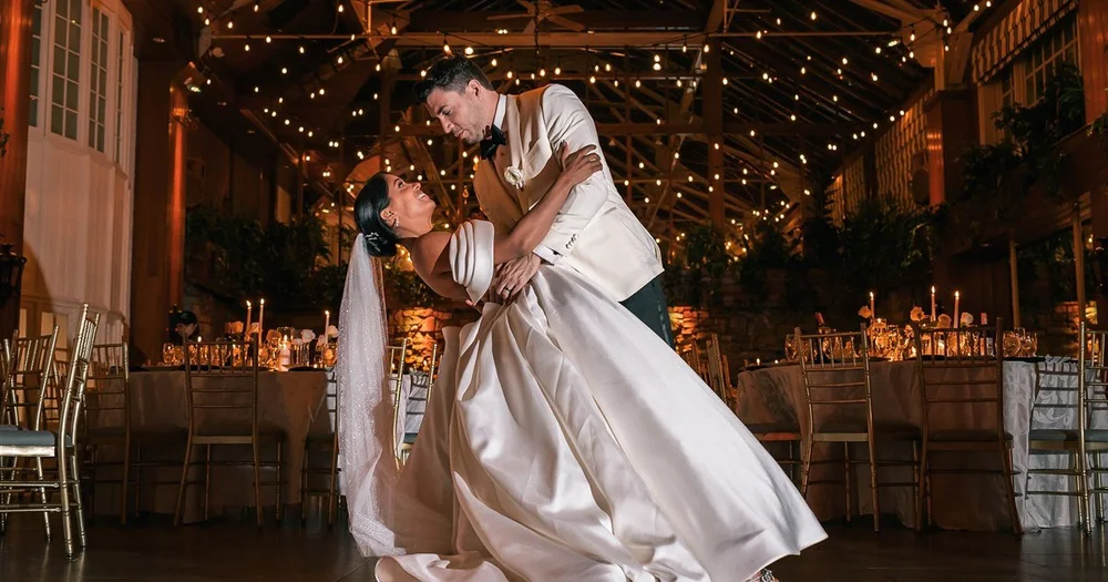 A couple dancing beneath strings of lights in The Somerley ballroom at Fox Hollow in Woodbury, New York