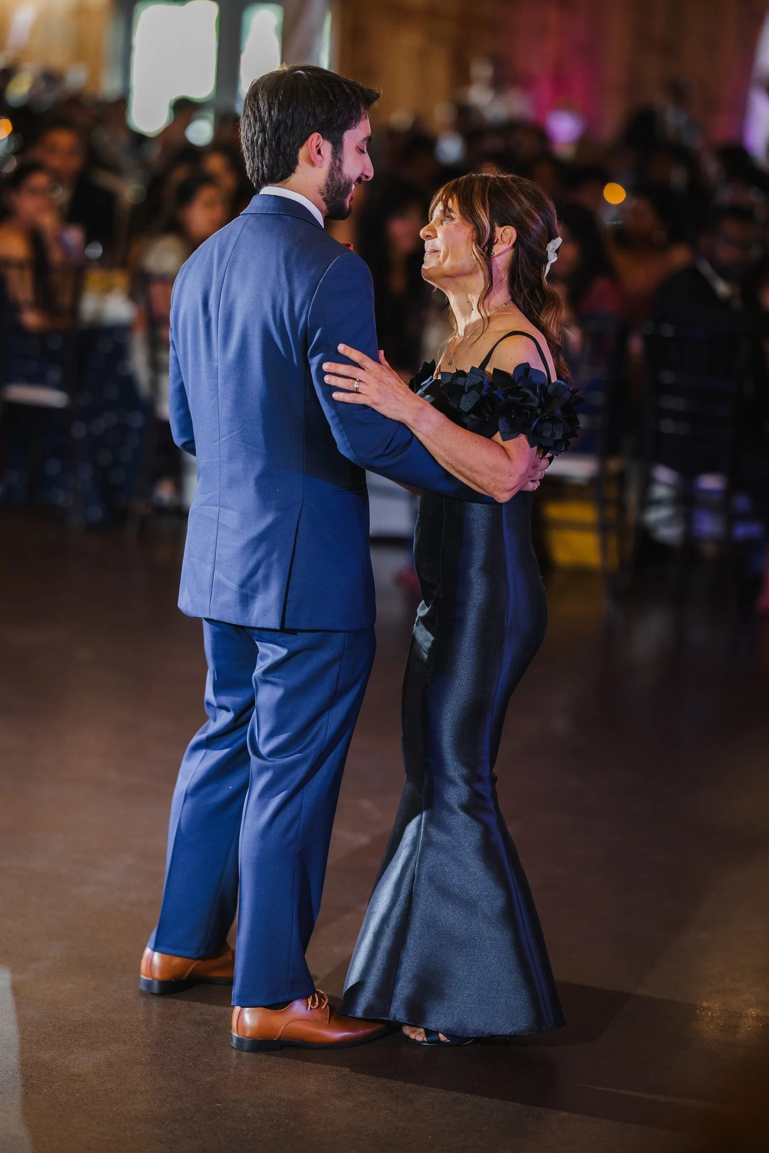 Ansel dancing with a woman in a long navy dress during the reception