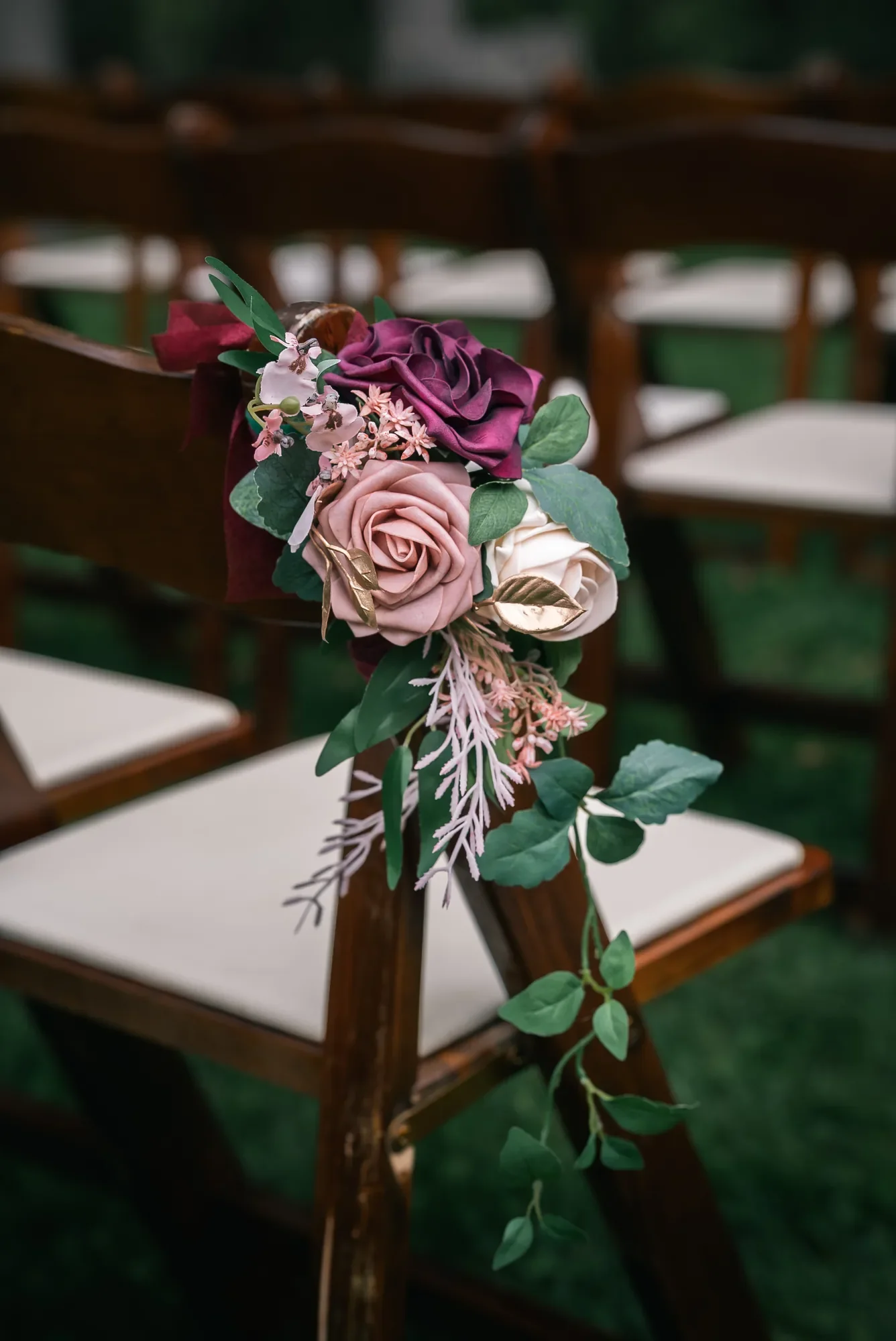 Burgundy and blush floral arrangement on a ceremony chair at Stoney Creek Castle