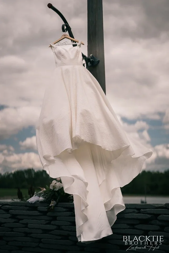 A wedding dress hanging outdoors against the sky at Graceful Gatherings at LedgeRock.