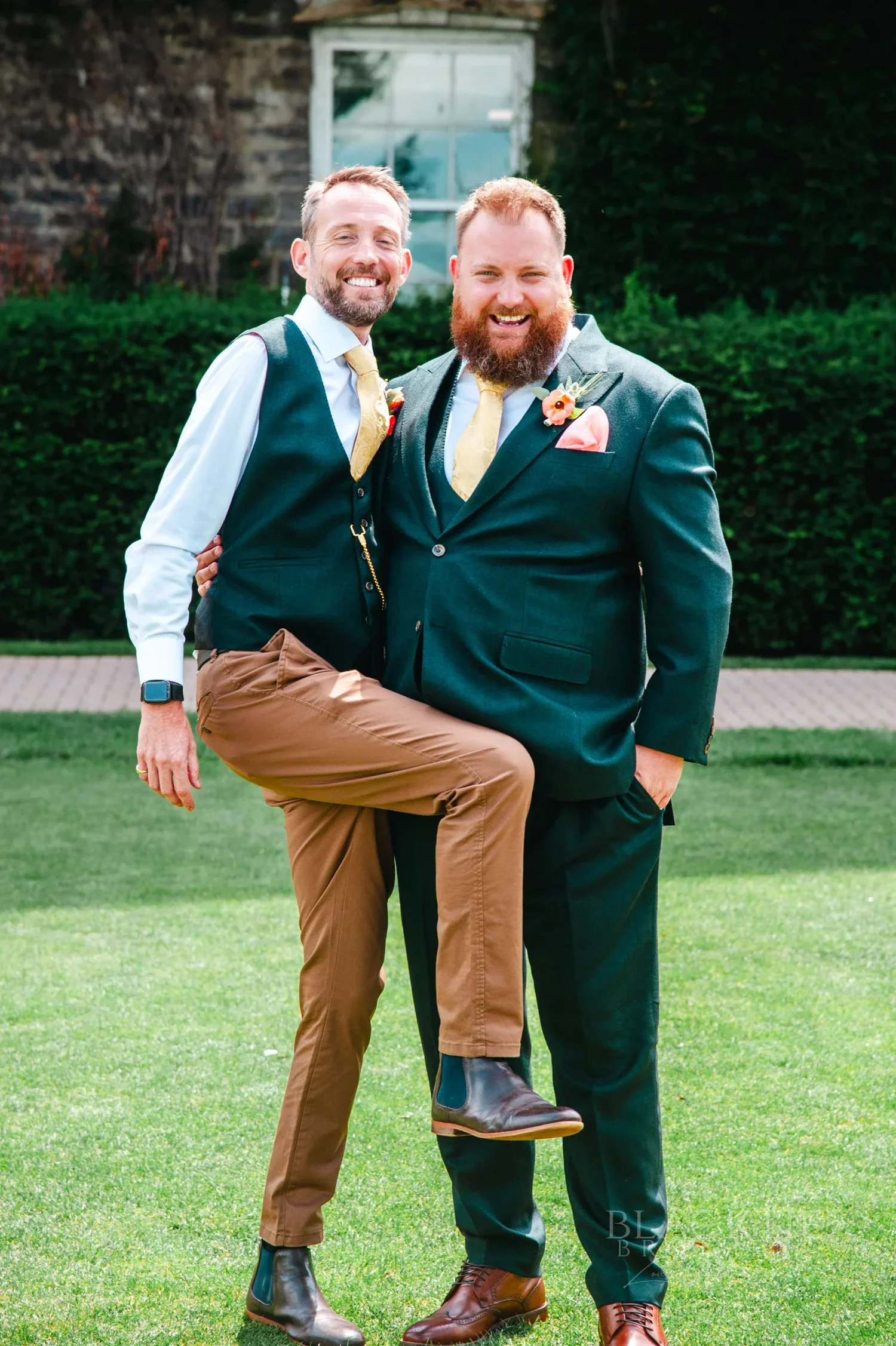 Chris and a groomsman in green waistcoats, one mid leg kick, on The Otesaga lawn