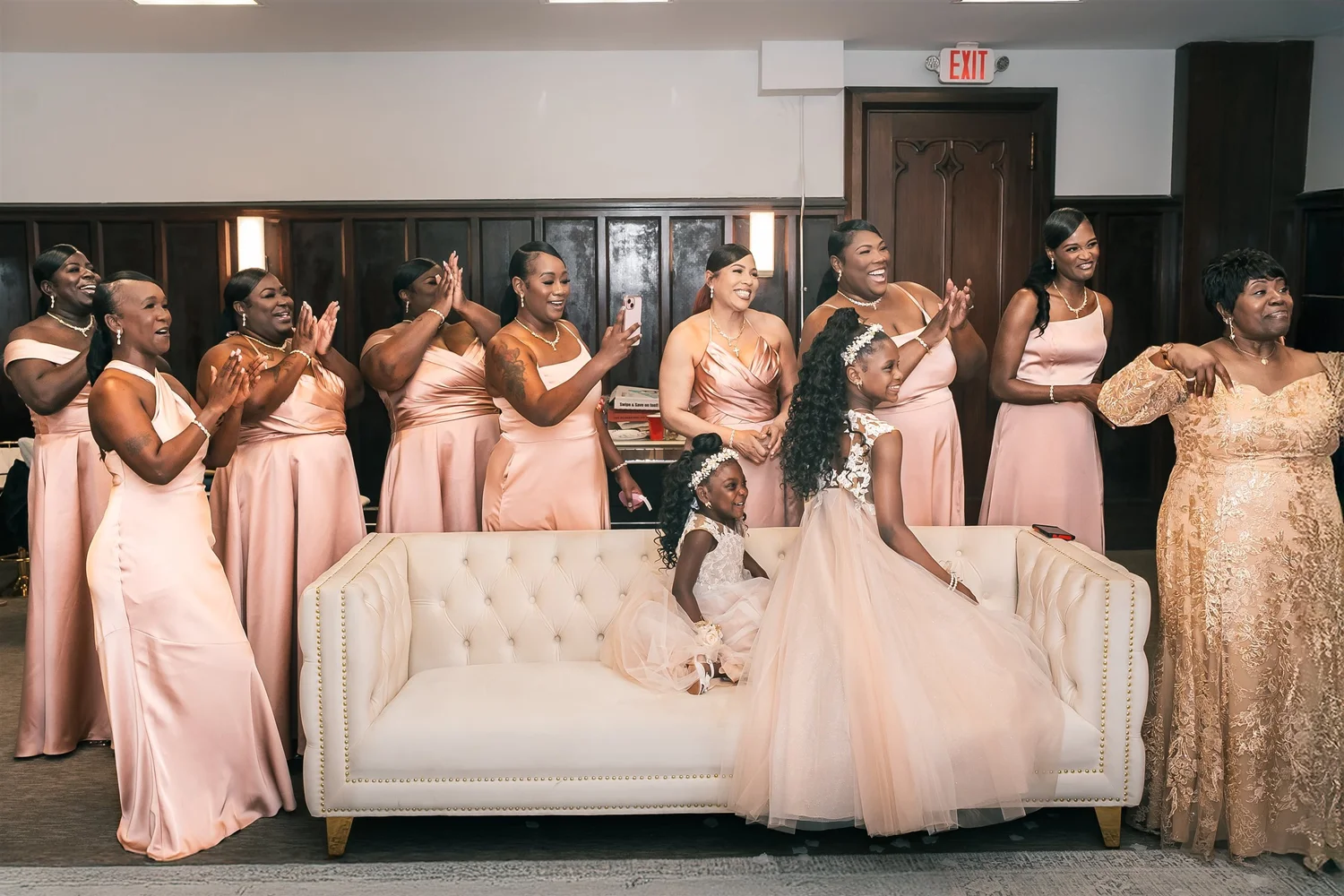 Tiffany and her wedding party gathered around a white sofa before the ceremony.