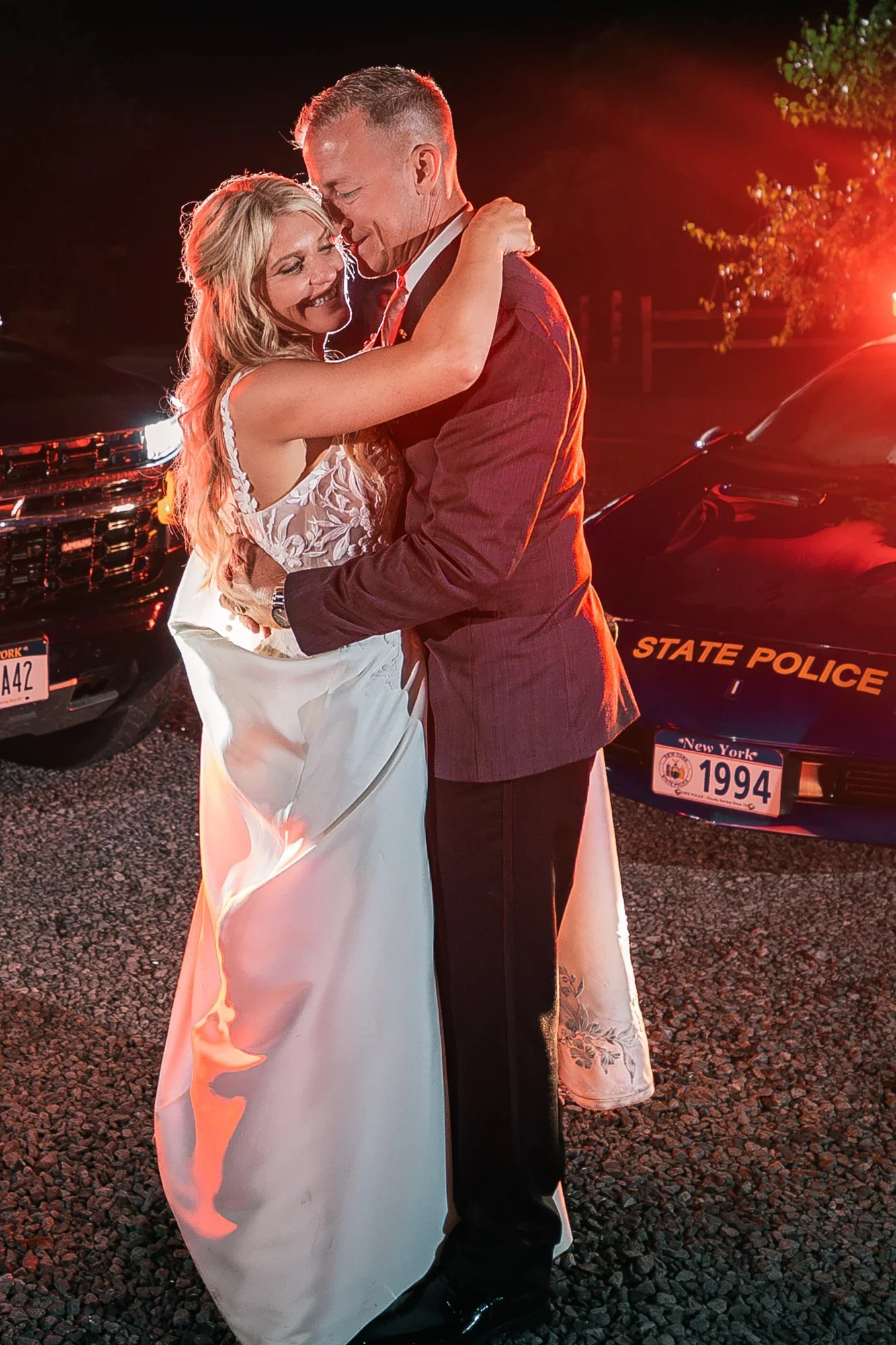 Night portrait of the couple lit in red on the LedgeRock grounds.