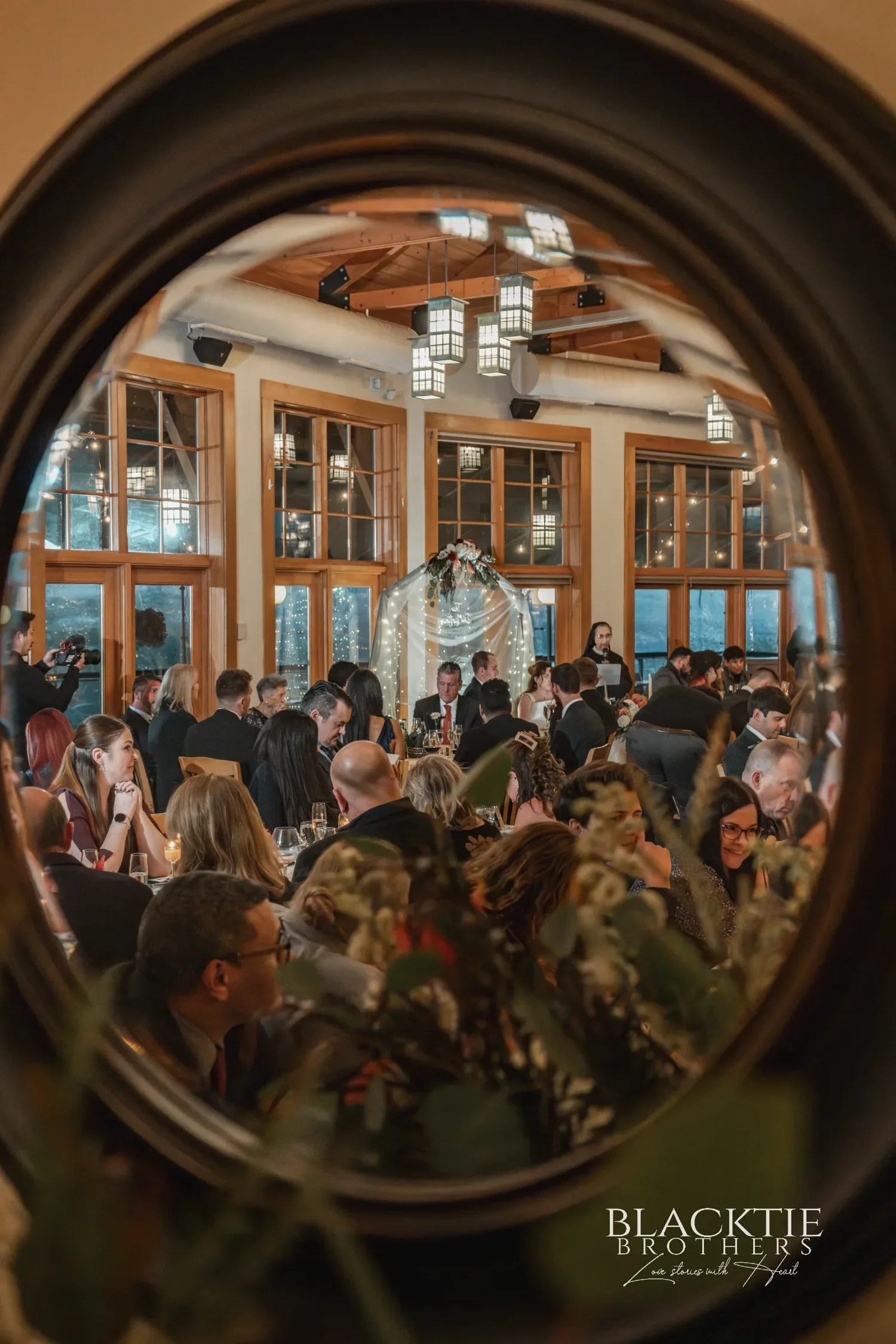 The reception room at Glenora seen reflected in a round mirror on the wall, guests at their tables